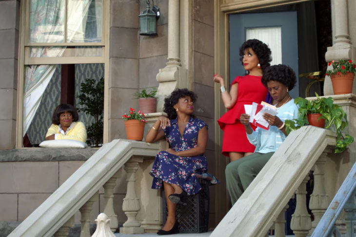 Grupo de mujeres reunidas frente al portico en unas escaleras, escena de la serie  A Black Lady Sketch Show