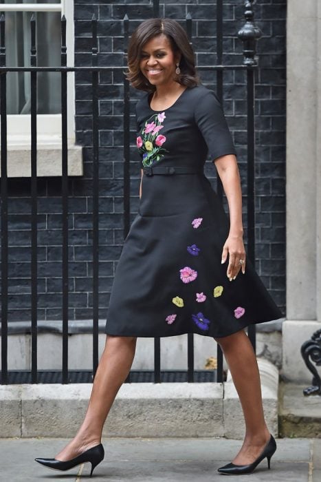 Michelle Obama sonriendo y caminando por la avenida 