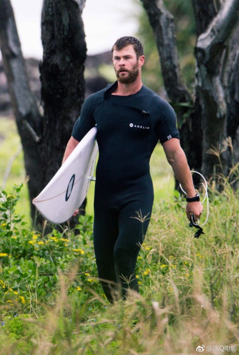 Chris Hemsworth en un traje de neopreno practicando surf