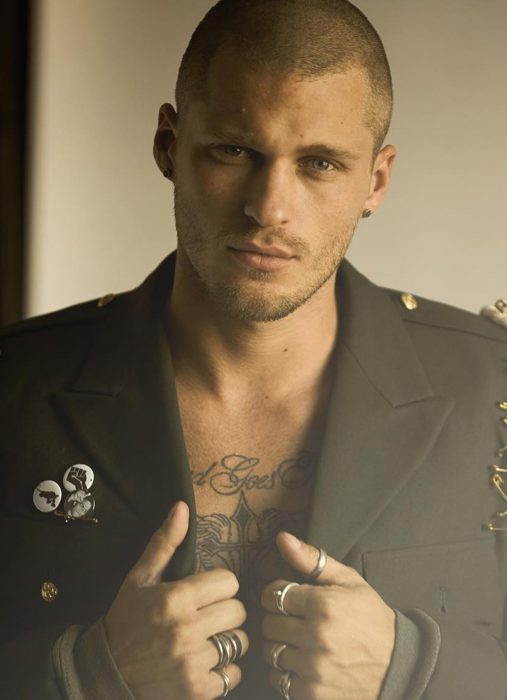 Hombre ruso guapo con tatuaje en el pecho y saco estilo militar