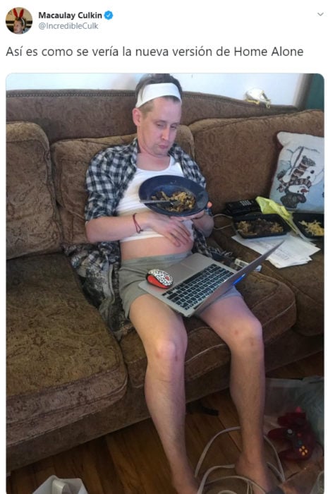Macaulay Culkin sentado en un sofá con una computadora en sus piernas y comiendo sobras 