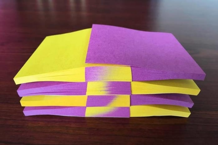 Hojas de Post-it en color morado y amarillo empalmadas de manera perfecta 