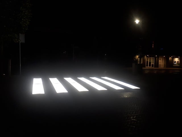 Paso peatonal pintado en blanco e iluminado 
