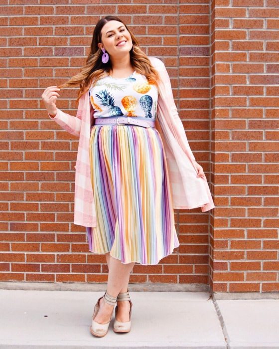 Atuendos para chicas plus size; chica con falda tableada de colores y blusa con estampado de piñas