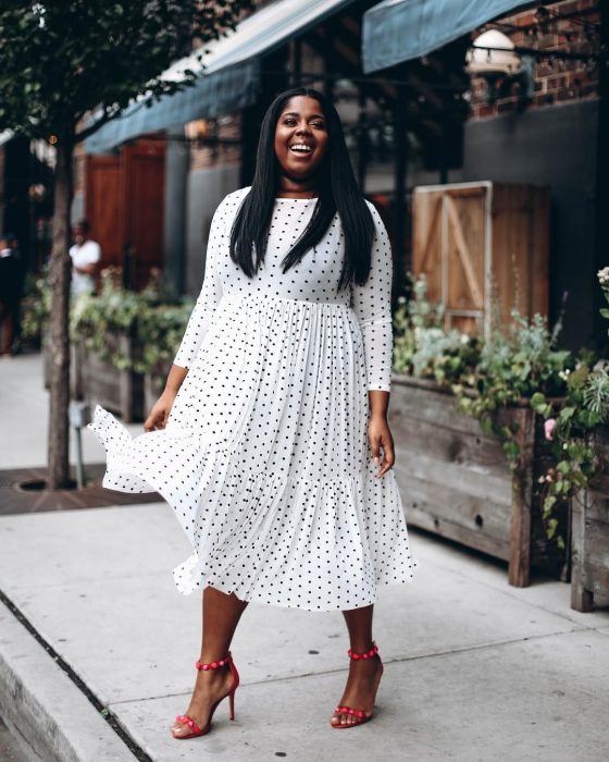 Atuendos para chicas plus size; chica morena con cabello lacio y vestido blanco con polka dots