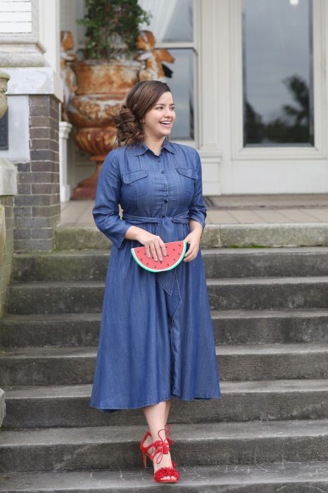 Atuendos para chicas plus size; chica con vestido denim y bolsa de mano en forma de sandía