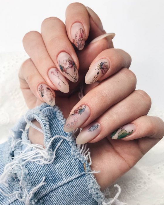 Manicura; uñas de almendra estilo boho con cráneos, flechas, plumas y flores