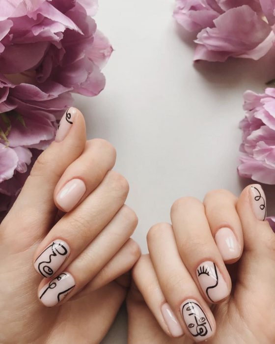 Manicura; uñas color carne con diseño de dibujo de rostros estilo Picasso