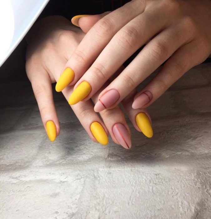 Manicura; uñas de almendra color amarillo canario y rosa palo con líneas horizontales y verticales