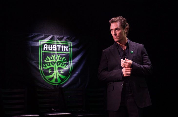 Matthew McConaughey posando para la foto del cartel de la Universidad de Texas 