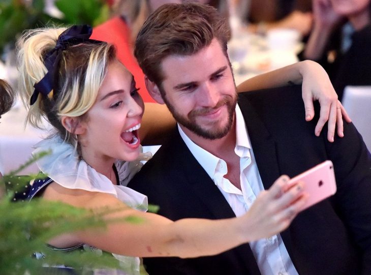 Miley Cyrus tomándose una foto con Liam Hemsworth