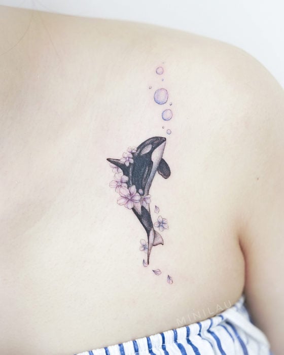 Tatuadora china, Mini Lau; tatuaje pequeño y femenino con colores pastel de orca con flores y burbujas