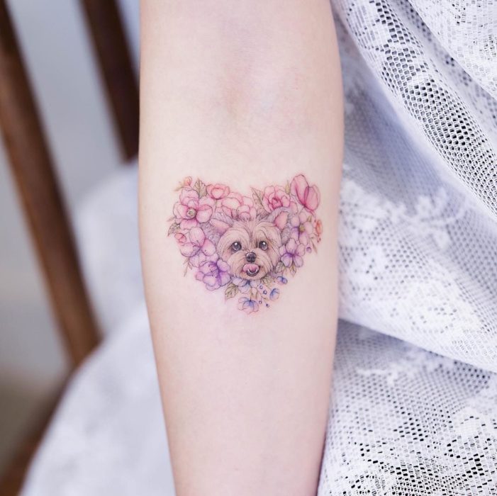 Chinese tattoo artist, Mini Lau;  Small and feminine tattoo with pastel colors yorkie dog in a heart of flowers