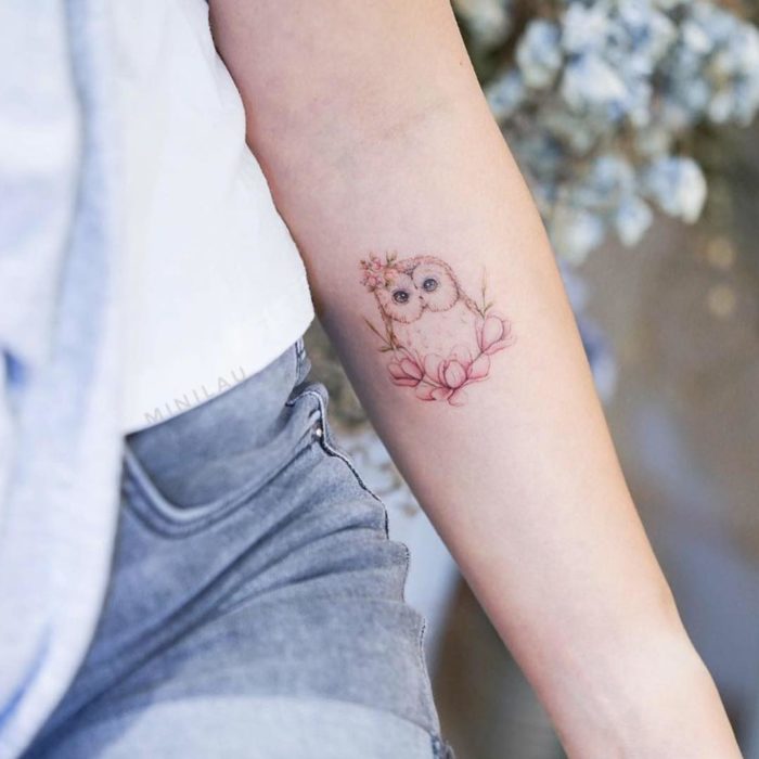 Tatuadora china, Mini Lau; tatuaje pequeño y femenino con colores pastel de búho bebé con flores rosas