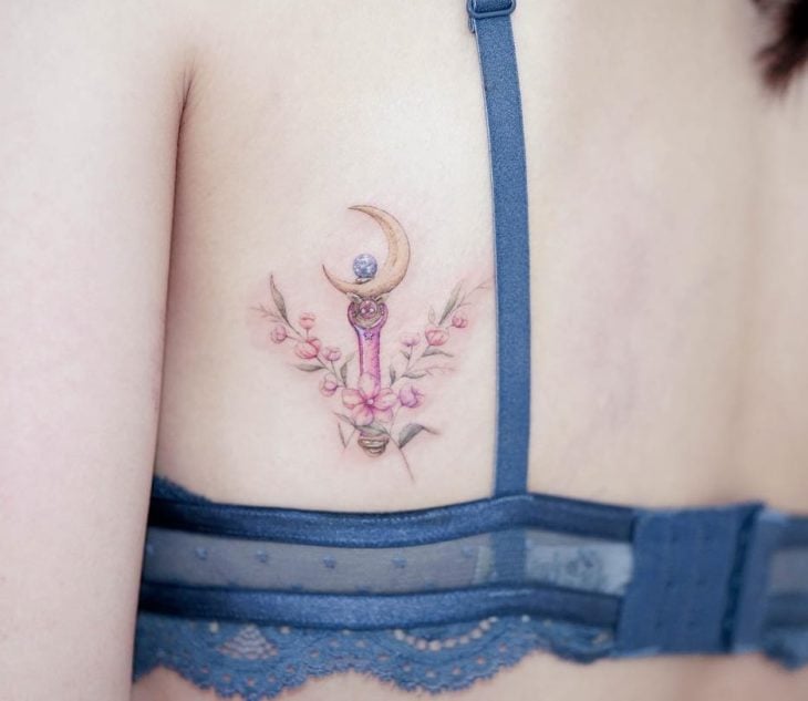 Chinese tattoo artist, Mini Lau;  Small, feminine pastel colored Moon Scepter tattoo by Serena on Sailor Moon