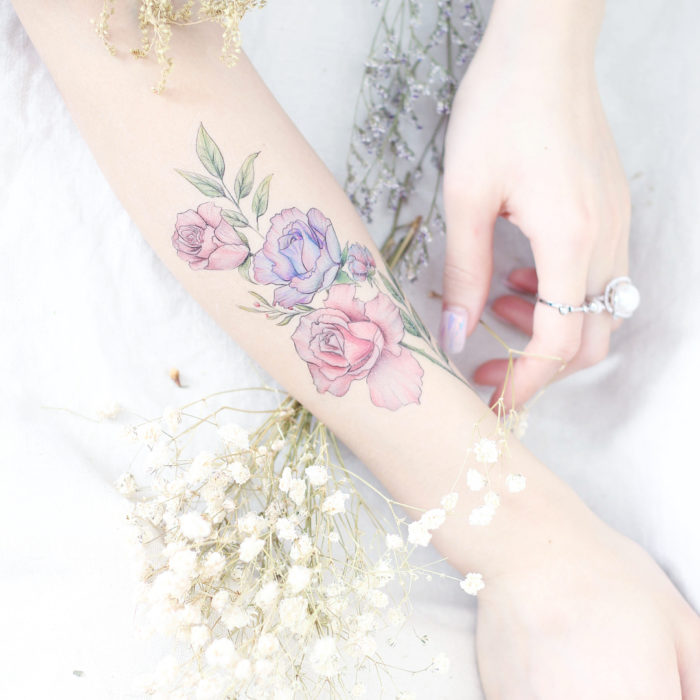 Chinese tattoo artist, Mini Lau;  Small, feminine tattoo with pastel rose colors on the arm