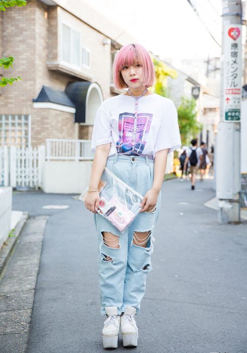 Moda japonesa harajuku; chica de cabello corto y rosa, con playera oversized, mom jeans desgastados, bolsa transparente, arnés y zapatos de plataforma