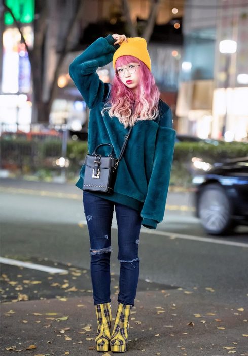 Moda japonesa harajuku; chica de cabello rosa, con gorro amarillo, suéter holgado verde de terciopelo, pantalones ajustados y botas amarillas de cuadros