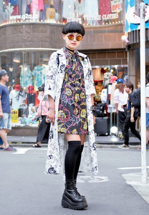 Moda japonesa harajuku; mujer de cabello corto, con lentes redondos tornasol, vestido floral y kimono con estampado de dinujos, zapatos de plataforma con calcetas