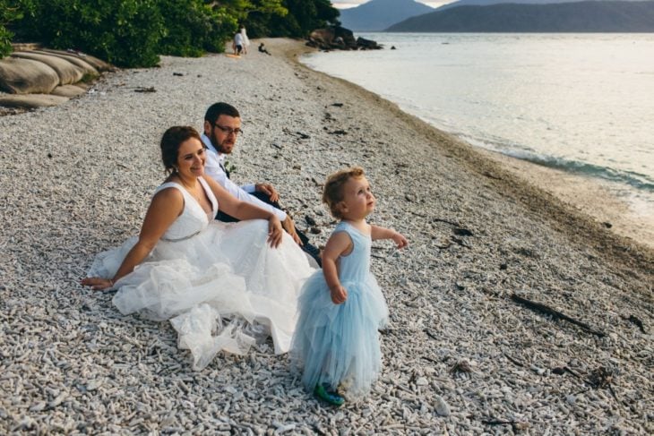 Joanna Minuzzo dejó que su hijo usara vestido azul el día de su boda; esposos e hijo en la playa junto al mar