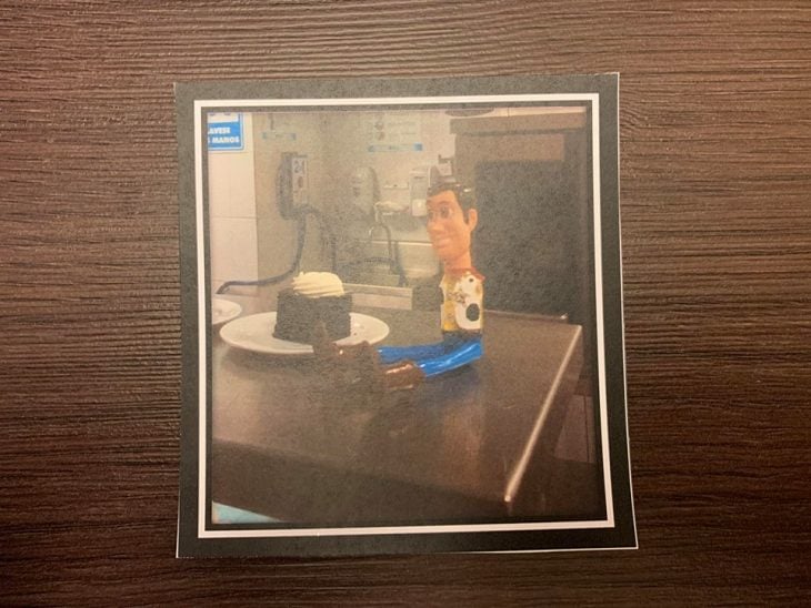 Fotografía sobre una mesa de madre con Woody comiendo pastel