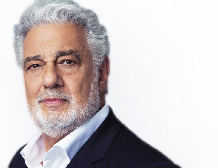 Plácido Domingo con traje negro, camisa blanca y fondo blanco