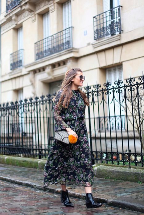 Chica usando un vestido de estampado floral con botas vaqueras 