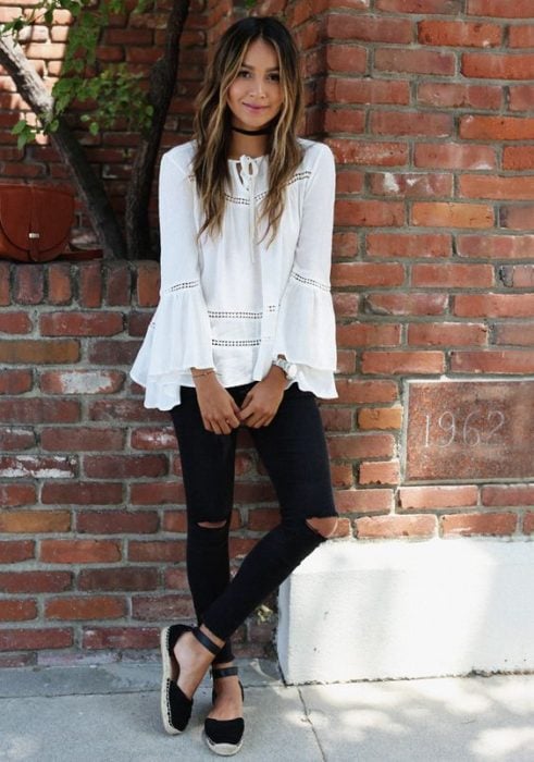 Chica usando una blusa blanca, jeans negros y alpargatas en color negro
