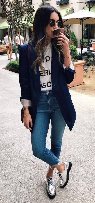 Chica usando un blazer negro, jeans y zapatos plateados 