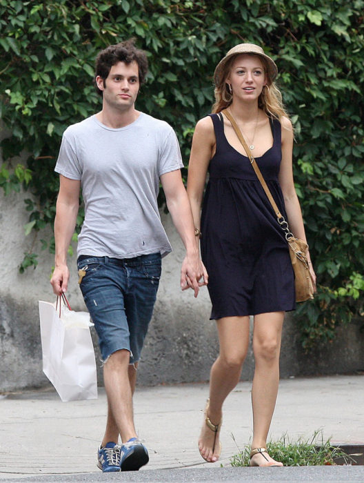 Penn Badgley y Blake Lively tomados de las manos y caminando por la playa