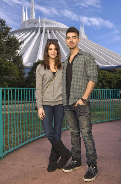 Joe Jonas y Ashley Greene posando para una foto mientras están en un parque 