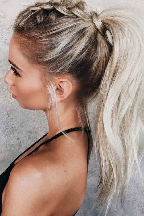 Chica con cabello balayage peinado en una ponytail alta con trenzas y ondas