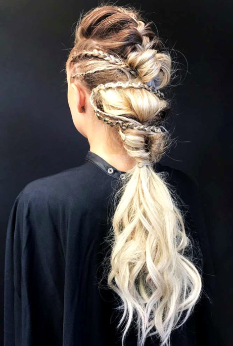 Mujer con cabello rubio largo y peinado de vikingo estilo Lagertha, trenzas y cola de caballo con crepé