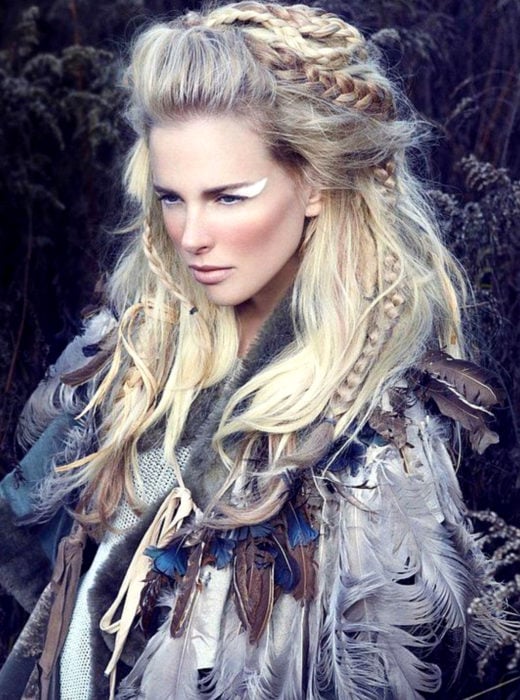 Mujer rubia vestida de vikinga, con plumas, con peinado de trenzas esponjado con crepé