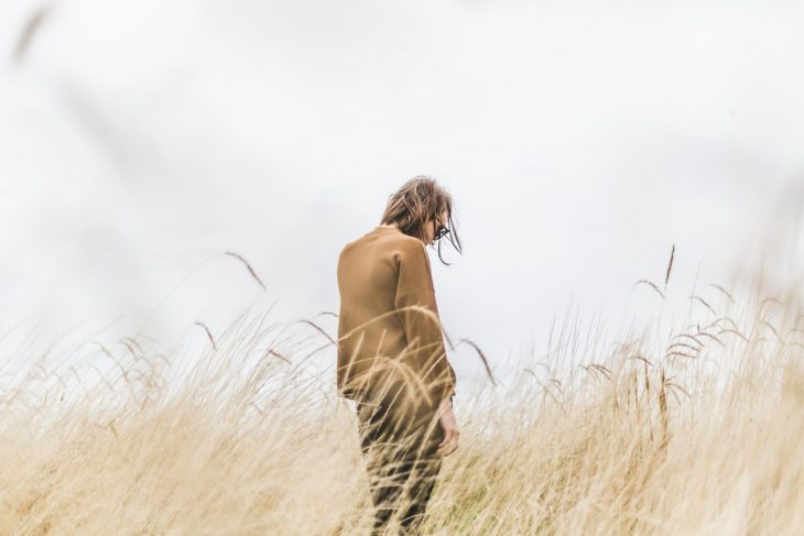 Mujer sola cabello corto en paisaje de pastizal