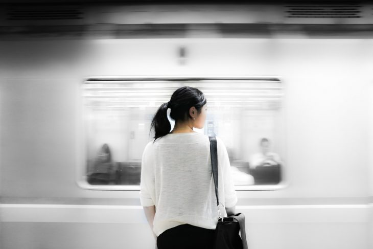 Mujer sola de espaldas en estación de metro