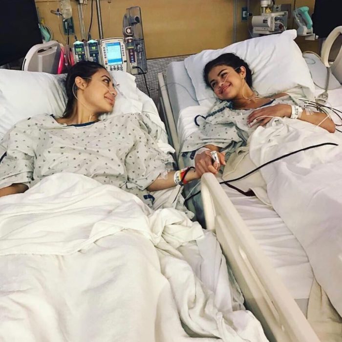 Selena Gomez y Francia Raisa recostadas en camillas de hospital y sujetadas de las manos