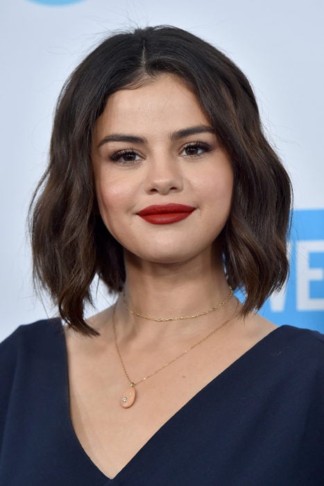 Selena Gomez posando para una fotografía en una alfombra roja