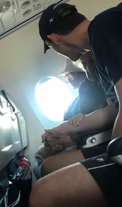 Chico sosteniendo la mano de una abuelita de 96 años en pleno vuelo