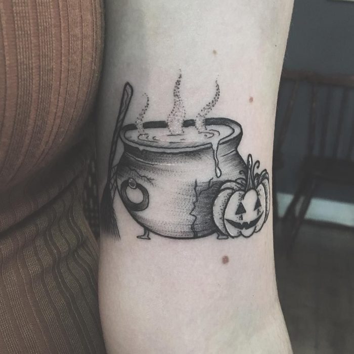 Tatuaje de halloween, caldero de bruja con calabaza y escoba en estilo minimalista en blanco y negro