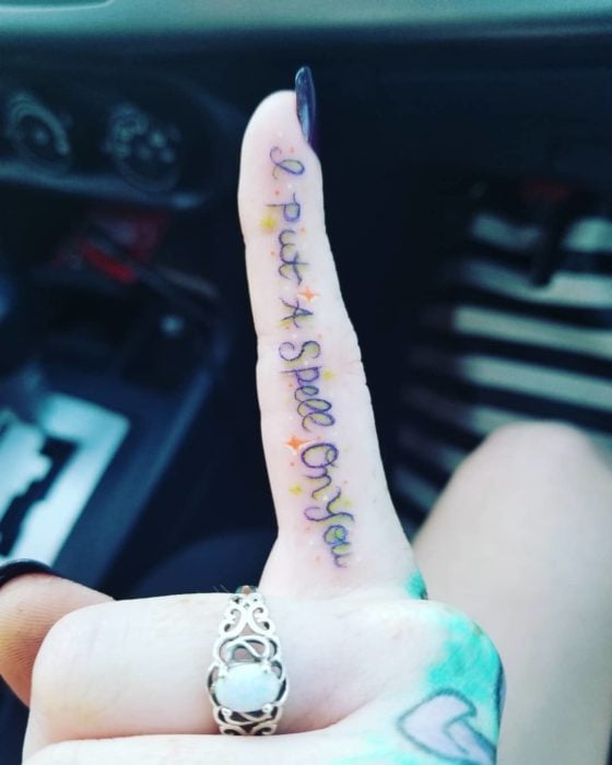 Dedo de mujer con un tatuaje en frase inspirado en Hocus Pocus