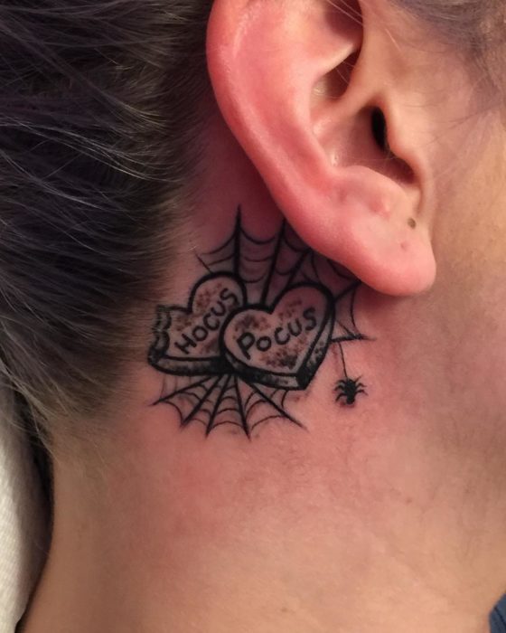 Tatuaje detrás de un oído con las pastillas en forma de corazón que aparecen en la película Hocus Pocus 