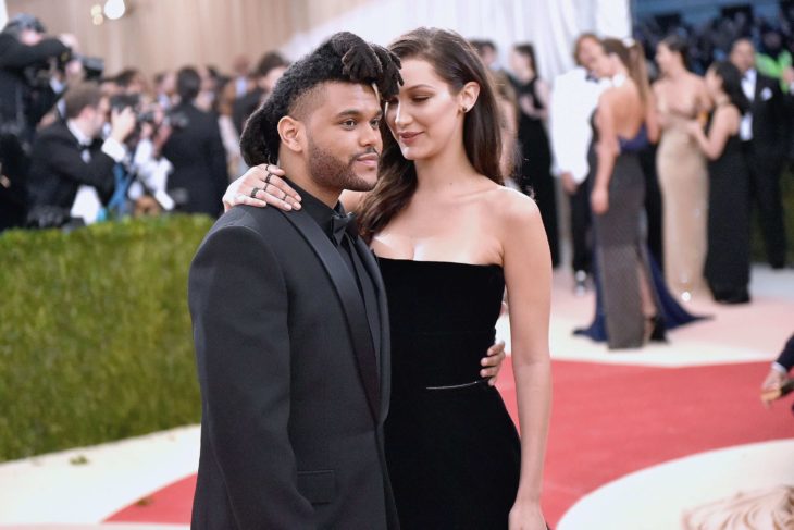 The Weeknd y Bella Hadid en alfombra roja vestidos de negro y abrrazados