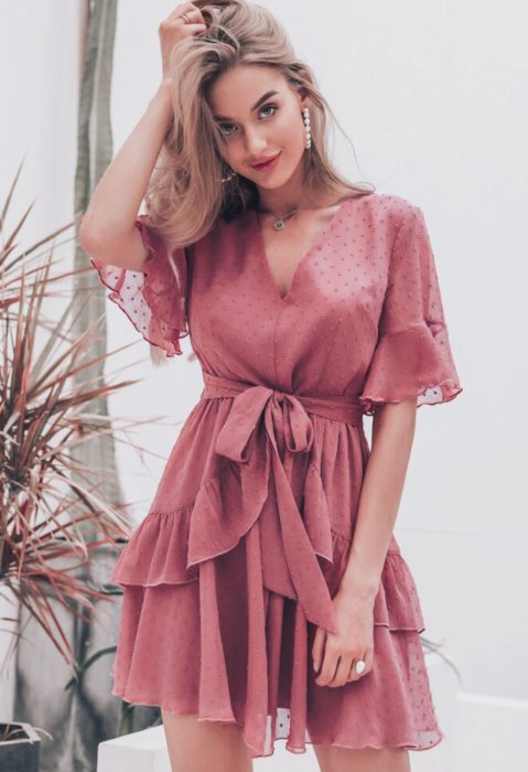 Chica rubia con vestido eestilo playero, rosa con lunares y olanes