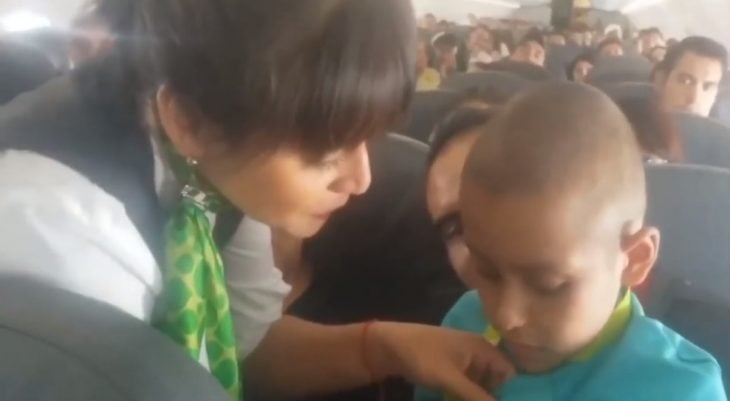 Azafata Cynthia Borges poniendo su insignia a Jonathan durante el vuelo a Mazatlan 