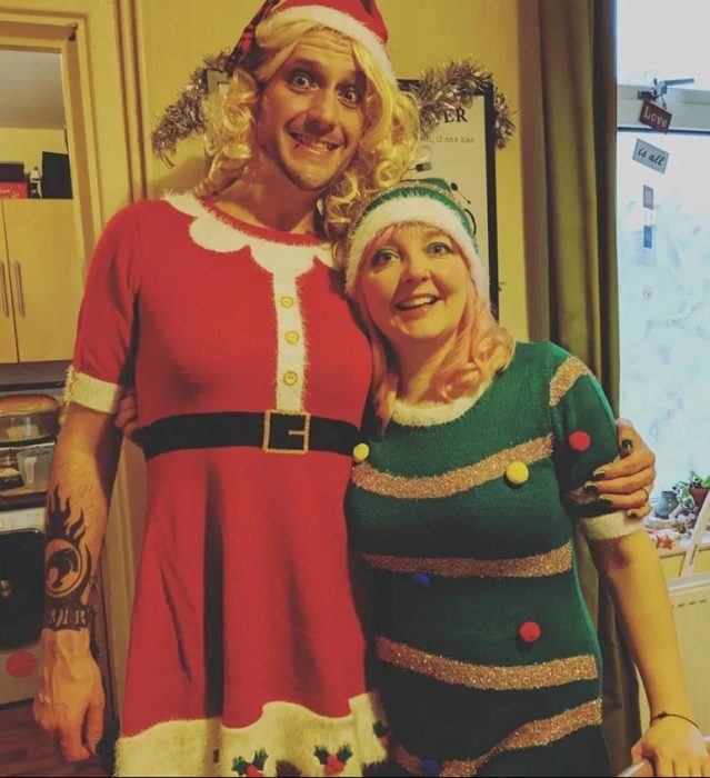 Warren Allen vestido de Papá Noel versión mujer y su esposa Kelly de duende verde