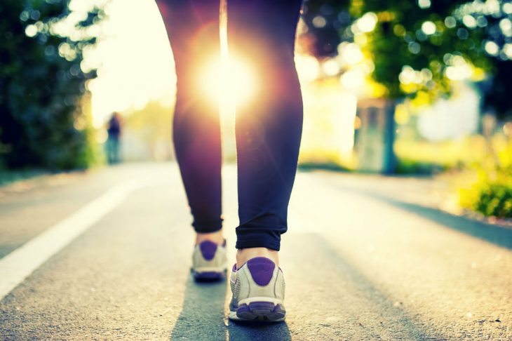 Piernas de mujer con tenis deportivos caminando 