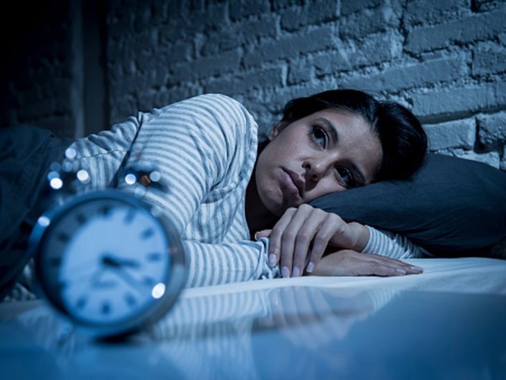 Mujer con cansancio acostada y abrazando la almohada