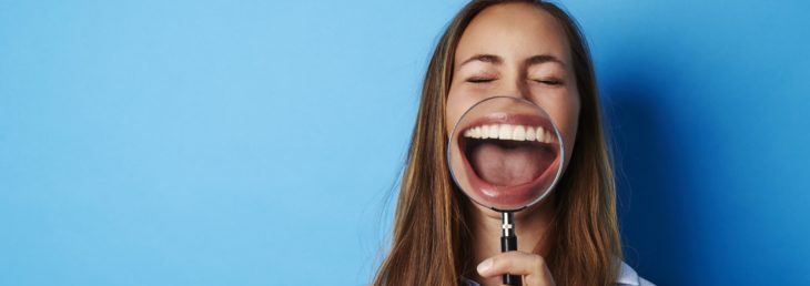 Mujer con una lupa en sus dientes