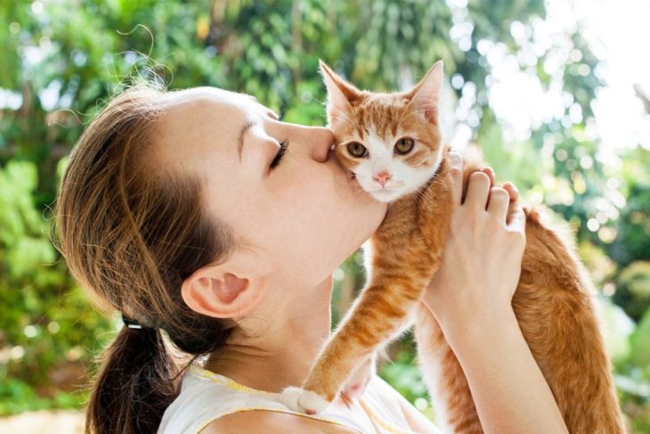 Mujer besando a su gato